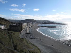 a view of a beach with buildings and the ocean at The Glengower in Aberystwyth