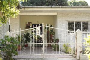 a white gate in front of a house at Backpacker Kitara House in Tarapoto