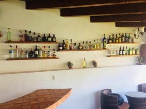 a bar with a lot of bottles on the wall at Hotel SKY & PALMS in Xochitepec