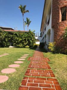 a brick pathway next to a building with palm trees at Hotel SKY & PALMS in Xochitepec