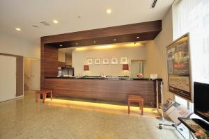 a lobby with a bar with two chairs and a counter at Dormy Inn Matsumoto in Matsumoto