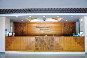 a restaurant with a large wooden wall in a building at Maihom Resort Hotel in Nakhon Sawan