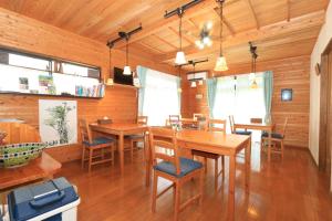 Minshuku nicoichi في ياكوشيما: غرفة طعام مع طاولات وكراسي خشبية