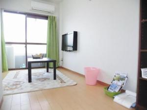 un soggiorno con tavolo e TV a parete di Private House Sora / Vacation STAY 1123 a Sakai