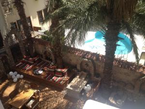 an overhead view of a pool with palm trees and benches at Mavi & Ani Pansiyon in Antalya