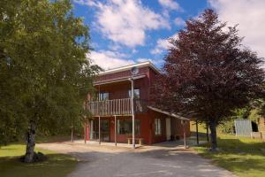 a red building with a balcony on the side of it at Crescent House in Wanaka