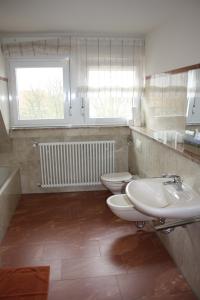 a bathroom with two toilets and a sink and a window at Thai Tawan in Rheinhausen