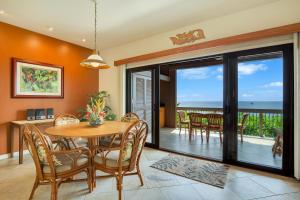 uma sala de jantar com mesa e cadeiras e o oceano em Castle Kanaloa at Kona em Kailua-Kona