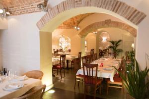 a restaurant with white tables and chairs and an archway at Hotel Plaza Grande in Zafra