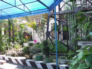 einen Garten mit vielen Pflanzen in einem Gebäude in der Unterkunft Armi Hotel Malang in Malang