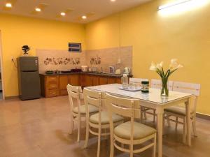 a kitchen with a table and chairs and a refrigerator at Thu Linh Homestay in Da Lat