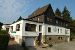 una casa blanca con techo negro en Haus Hesseberg, en Medebach