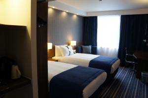 una camera d'albergo con due letti e una finestra di Holiday Inn Express Earls Court, an IHG Hotel a Londra