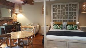 a bedroom with a bed and a table and a dining room at Ballina Palms Boutique Motel in Ballina
