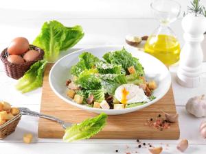 a salad in a white bowl on a cutting board with eggs at Ibis Bangkok Riverside in Bangkok