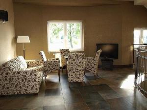 a living room with a couch and chairs and a television at Zajazd Kmicic in Zemborzyce Dolne