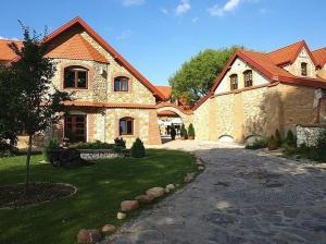 a large stone house with a pathway in front of it at Zajazd Kmicic in Zemborzyce Dolne