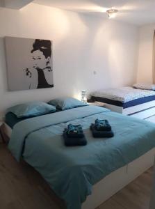 um quarto com uma grande cama azul e 2 camas em Residentie Hippocampe em Wenduine