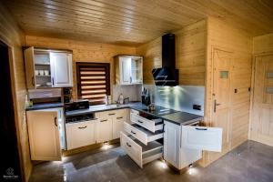 ソリナにあるKaliMeraの白い家電製品と木製の壁が備わるキッチン