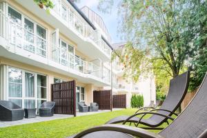 a row of chairs on a lawn in front of a building at Best Western Plus Parkhotel Erding in Erding