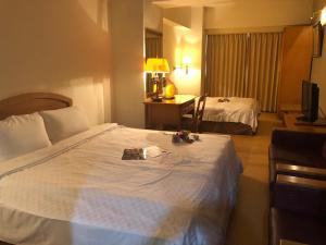 Voodi või voodid majutusasutuse Berkeley Business Hotel Zhongzheng toas