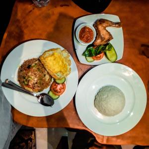 zwei Teller Essen auf einem Holztisch in der Unterkunft Ogix Cliff Paradise in Nusa Penida + 20 Fotos