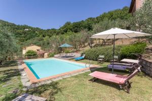 a swimming pool with an umbrella and two chairs at Villa Mastiano in Mastiano