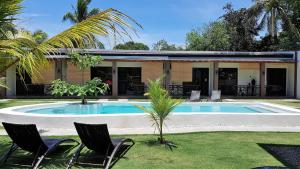 a house with a swimming pool and two chairs at Positano Alona Beach Panglao in Panglao