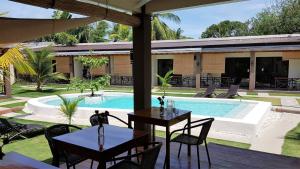 a patio with tables and chairs next to a swimming pool at Positano Alona Beach Panglao in Panglao