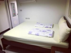 Bett in einem Zimmer mit zwei Kissen darauf in der Unterkunft Dongyin First Homestay in Dongyin/