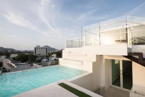 a swimming pool on the roof of a building at Modern Thai Suites in Phuket Town