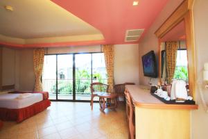 a hotel room with a bed and a desk in a room at Baan Boa Resort in Patong Beach
