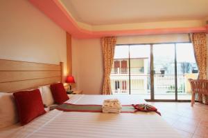 a hotel room with two beds and a large window at Baan Boa Resort in Patong Beach