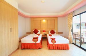 a hotel room with two beds and a window at Baan Boa Resort in Patong Beach