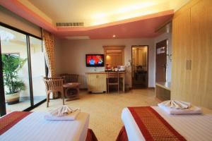 a hotel room with two beds and a television at Baan Boa Resort in Patong Beach