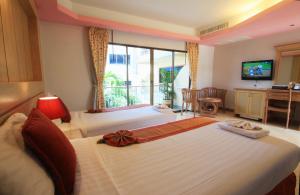 a hotel room with two beds and a balcony at Baan Boa Resort in Patong Beach