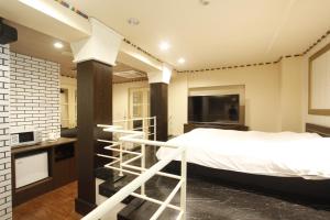 安約馬奇的住宿－豐田南諾亞酒店（僅限成人），一间带大床和电视的卧室