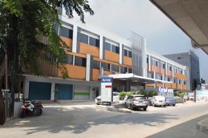 a building with cars parked in front of a parking lot at Kyriad Fatmawati Jakarta in Jakarta