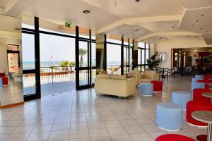 a lobby with couches and tables and a view of the ocean at Hotel Astoria in Pesaro
