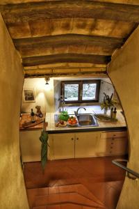 una pequeña cocina con fregadero y ventana en Pieve di Caminino Historic Farm, en Podere Caminino