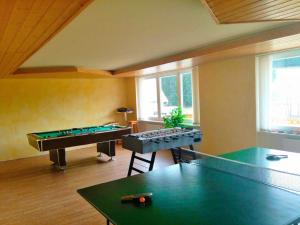 um quarto com uma mesa de pingue-pongue e mesas de bilhar em Akzent Hotel Kaltenbach em Triberg