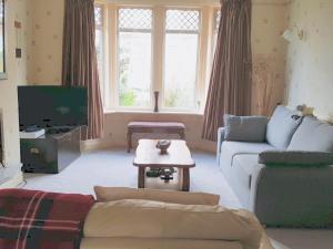 a living room with a couch and a tv at Charles's Street in Largs