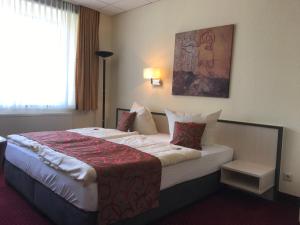 Un pat sau paturi într-o cameră la Parkhotel Neubrandenburg