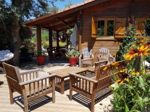 una terraza de madera con sillas y una mesa de madera. en Le Chalet de Valentine & Laurent en Olmiccia