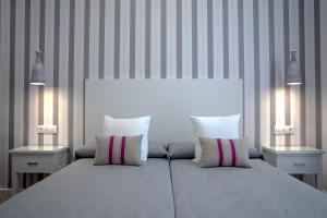 um quarto com uma cama grande e 2 mesas de cabeceira em Hotel Apartamentos MPD em Mérida