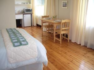 a bedroom with a bed and a table with a dining room at Dee's BnB in Pretoria