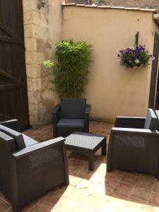 une terrasse avec des chaises, une chaise et une plante dans l'établissement Hôtel Restaurant de la Place, à Saint-Jean-dʼAngély