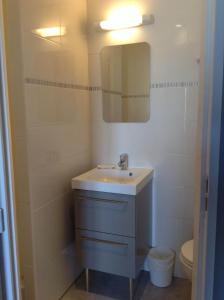 a bathroom with a sink and a mirror and a toilet at Hôtel Restaurant de la Place in Saint-Jean-dʼAngély
