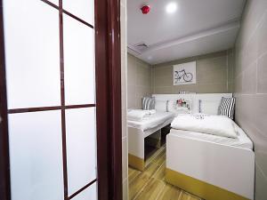 Habitación pequeña con 2 camas y mesa. en HK International Hostel, en Hong Kong