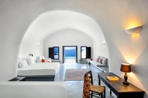 a living room with a white couch and a table at Grand Ambassador Santorini Hotel in Akrotiri